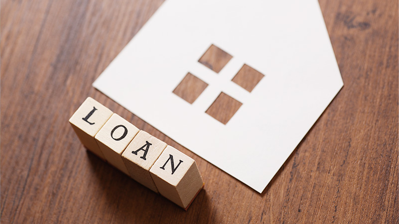 家の切り抜かれた白い紙とLOANと書かれたブロックの写真